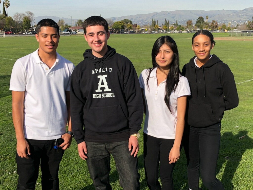 4 students wearing black and white - one with Apollo sweatshirt